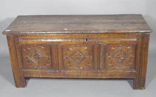 A 17th century oak coffer with plank top over a triple carved front panel on stile feet, 113cm wide x 51cm high x 46cm deep.  I9