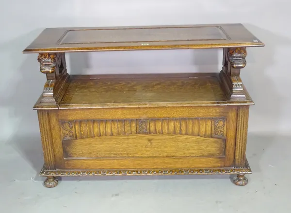 An 18th century style oak monk's bench with carved lion supports, 107cm wide x 73cm high.  E5