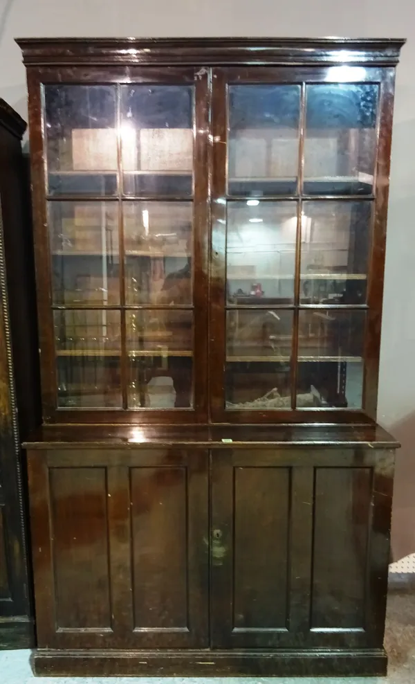 A 20th century mahogany bookcase cabinet with pair of glass doors over panelled door cupboard base, 127cm wide x 216cm high.  M5