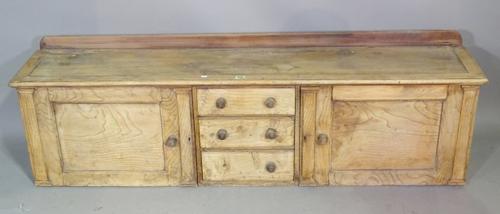 An early 20th century pine side cabinet with three short drawers flanked by cupboards 147cm wide x 45cm high.  K8