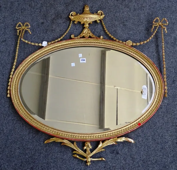 An Adams Revival gilt framed oval mirror with urn crest and ribbon tied floral swags, 88cm wide x 95cm high.  K10