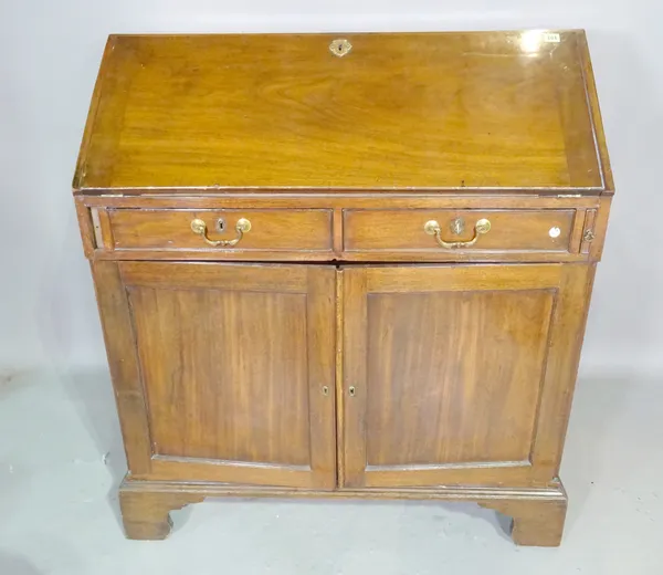 A George III mahogany bureau with fitted interior over two short drawers and pair of cupboards on bracket feet, 102cm wide x 114cm high x 55cm deep.