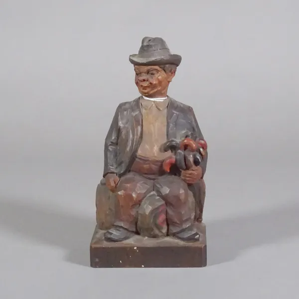 A tyrolean carved wood seated figure of a man, with music box inset.  CAB