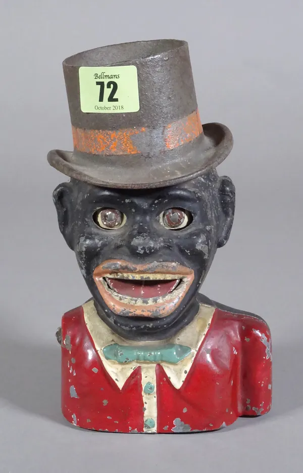 An early 20th century cast iron musical money box in the form of a golliwog.  CAB