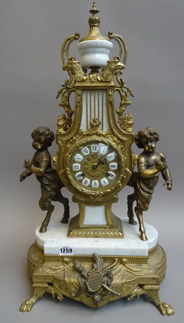 A Louis XVI style gilt metal and white marble mantel clock, 20th century, the lyre shaped body flanked by anthropomorphic figures enclosing a two trai