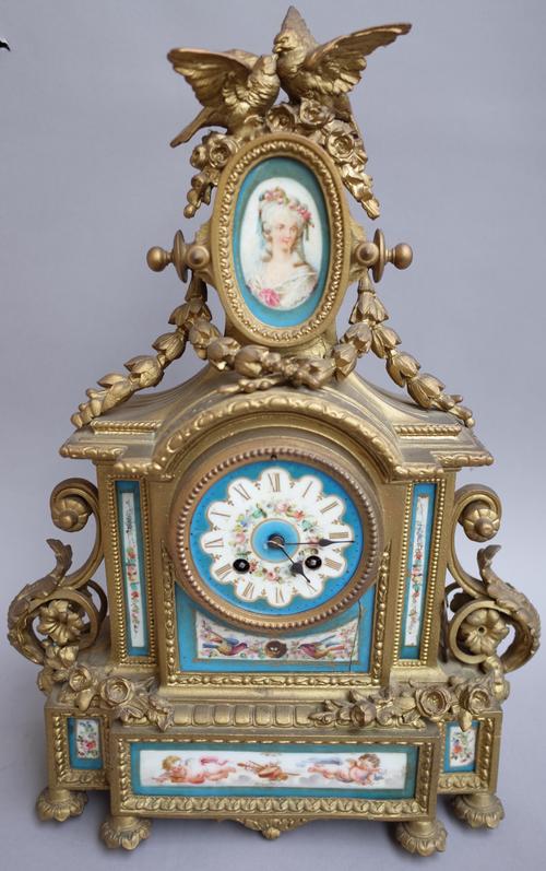 A French porcelain mounted gilt metal eight-day mantel clock, early 20th century, with bird surmount over an oval porcelain miniature plaque and paint