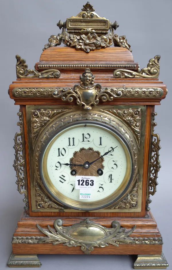 A Continental oak cased 8 day mantel clock, early 20th century, with enamel dial and gilt metal embellishments and a two train movement with hammer st