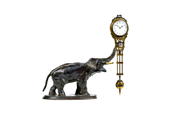 A composite bronze novelty elephant mantel clock, 20th century, the elongated trunk suspending movement and integral pendulum, elephant 17cm high. Ill