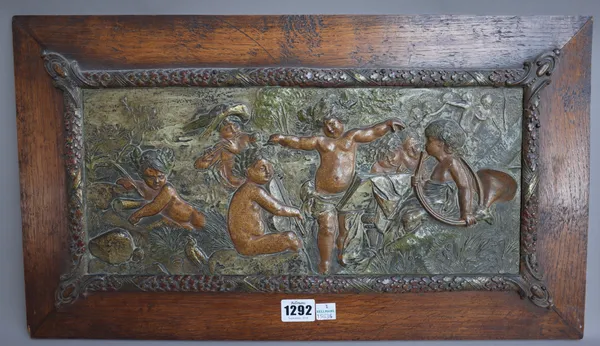 A pair of French polychrome spelter wall plaques, late 19th century, each relief cast with putto in a landscape emblematic of 'War & Music' mounted on