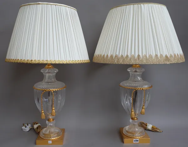 A pair of Victorian style glass and gilt metal urn form table lamps, modern, with swag embellishments, square foot and cream pleated silk shades, 74cm