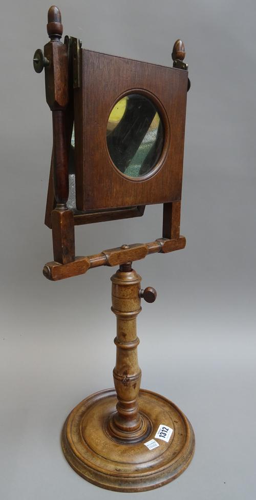 A late 19th century mahogany Zograscope with a hinged magnifier over an adjustable turned central support and base. 60cm high.