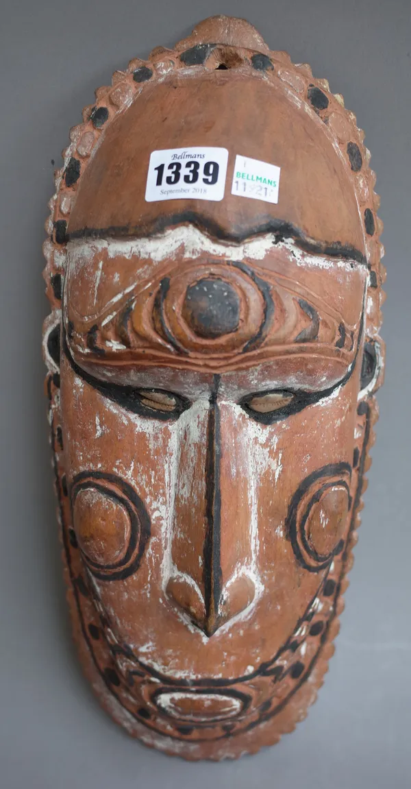A carved tribal wall mask, Papua New Guinea, with inset shell eyes and painted decoration, 36cm high.