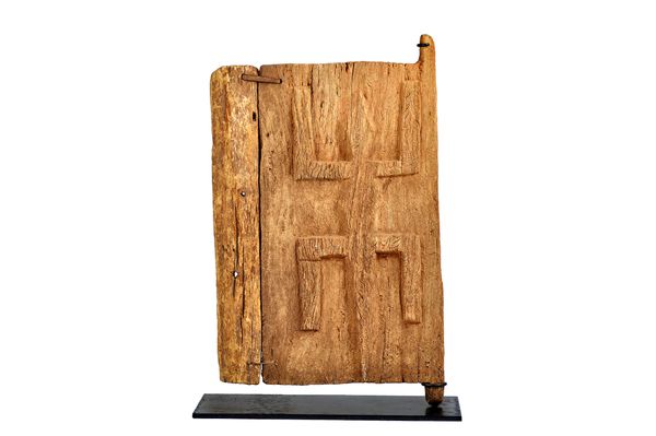 A Dogon wooden door on stand, Mali region, carved in relief with a crude reptile, displayed on a purpose made metal stand, door 77cm high x 47cm wide.