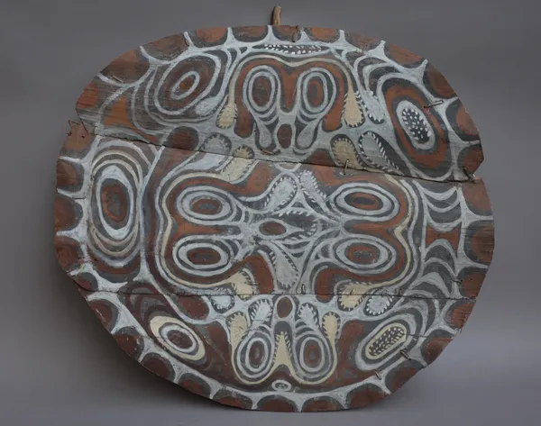 A Papua New Guinea polychrome painted house ornament of circular form, possibly a central roof hatch, detailed with geometric foliate pattern, 83cm di