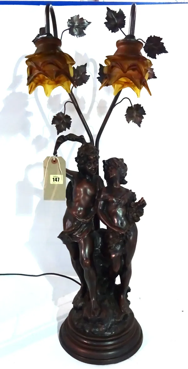 A 20th century resin table lamp formed as two cherubs with amber coloured glass shades, 80cm high.  A6