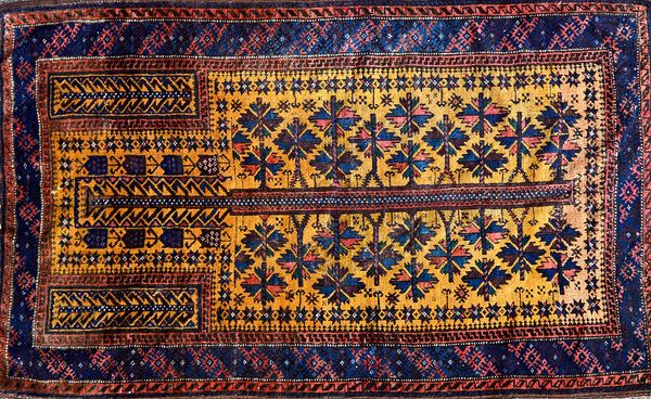 A Beluchistan prayer rug, the saffron mehrab with a flowering tree of life, plant spandrels, a banded border, flatweave end, 130cm x 80cm. Illustrated