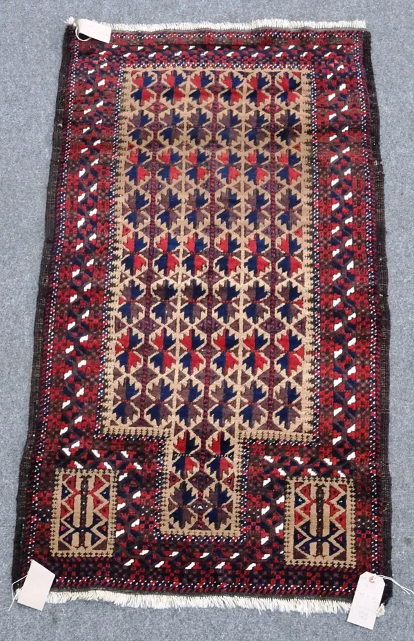 A Beluchistan prayer rug, the pale brown mehrab with matching three columns of flowering spandrels, plants, a leaf border, 148cm x 81cm