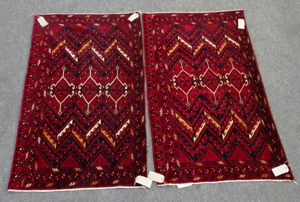 A pair of Uzbeck chuvals, the madder field with three single medallions zig-zag supporting bands, leaf border, skirt end, 93cm x 153cm, (2).