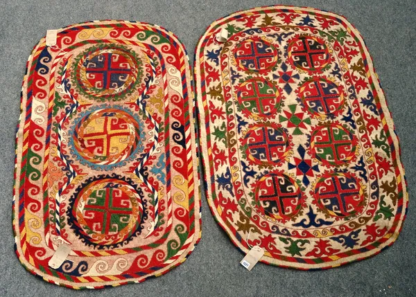 An Uzbek felt saddle cloth, the ivory field with two column of four cross roundels, an ivory border 144cm x 92cm and a similar with three single medal