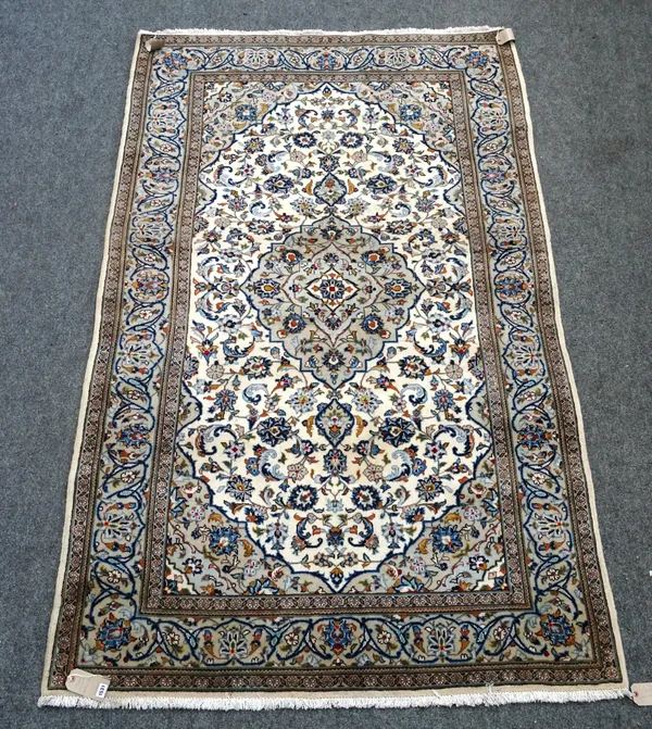 A Kashan rug, Persian, the ivory field with a grey medallion, matching spandrels, all with floral sprays, a grey complementary palmette border, 247 x