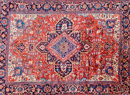 A Heriz carpet, Persian, the madder field with a bold central medallion, ivory spandrels, all with angular floral and leaf sprays, a dark indigo palme