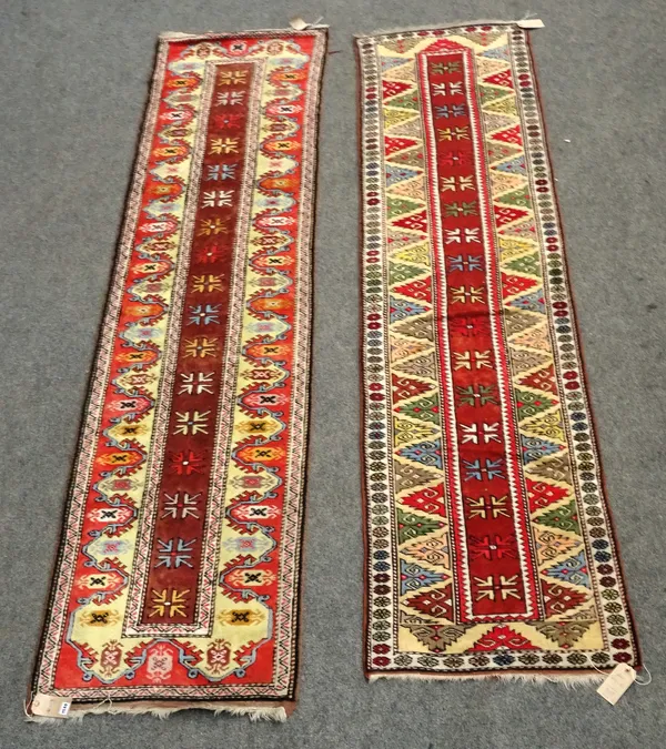 A Turkish runner, the brown field with single flowerheads, a wide yellow border with single triangular medallion, 280cm x 73cm and a similar runner, w