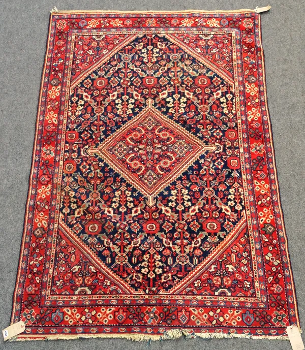 A Mahal rug, Persian, the dark indigo field with a madder central diamond, matching spandrels, all with a floral design, a madder floral border, 206 x