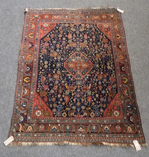 A Ghashgai rug, South Persian, the indigo field with a central medallion, madder spandrels, all filled with flowers, a madder palmette, leaf and vine