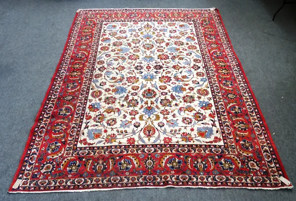 An Isfahan carpet, Persian, the ivory field with allover palmette and floral sprays, a madder complementary border, 402 x 295cm.