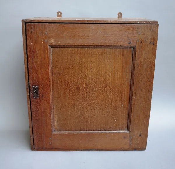 An 18th century and later oak and pine hanging spice cupboard, the single panel door enclosing seven drawers, 43cm wide x 48cm high x 15cm deep.