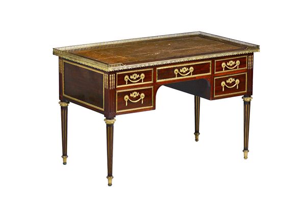 A Louis XVI style gilt metal mounted mahogany bureau plat/ writing desk, circa 1900, with five drawers about the knee on tapering fluted supports, 117