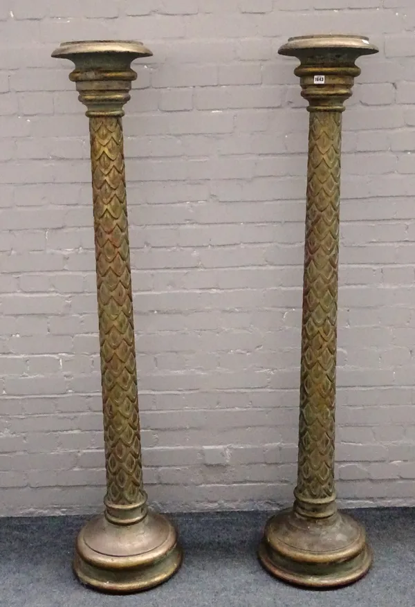 A pair of 18th century style parcel gilt green painted torcheres with scale carved column and stepped circular bases, 173cm high (2).