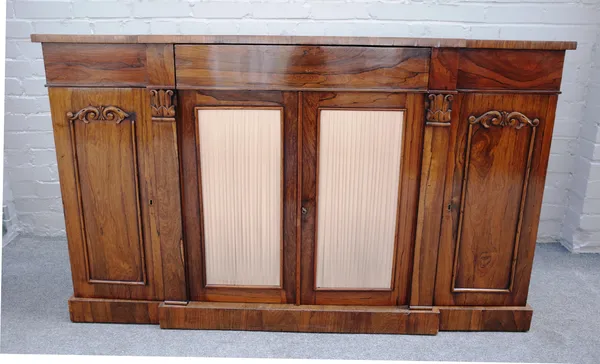 A William IV rosewood breakfront side cabinet, with three flush fit drawers, over a pair of pleated silk panel cupboards and a further pair of panel c