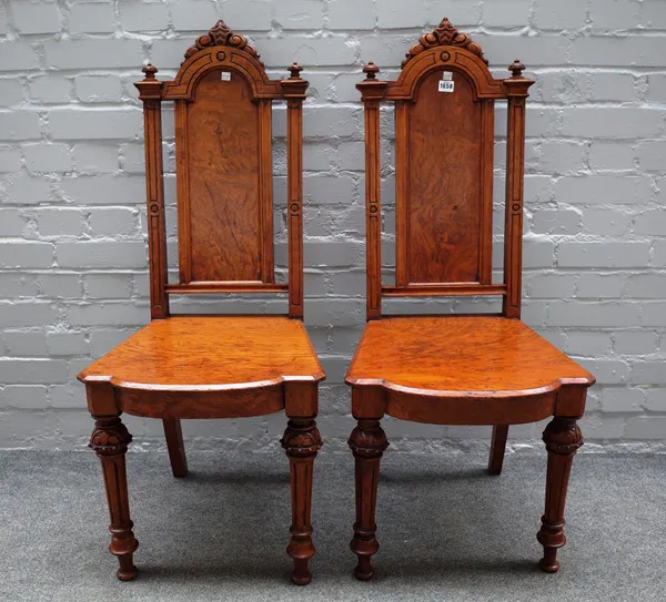 A pair of Victorian pollard oak hall chairs with solid arch back and seat on tapering fluted supports, 46cm wide x 108cm high, (2).