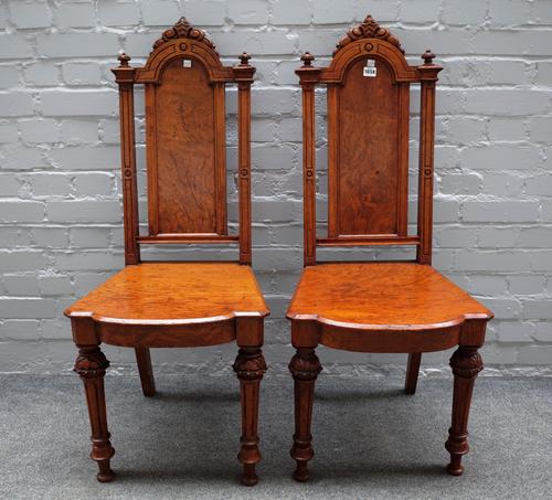 A pair of Victorian pollard oak hall chairs with solid arch back and seat on tapering fluted supports, 46cm wide x 108cm high, (2).