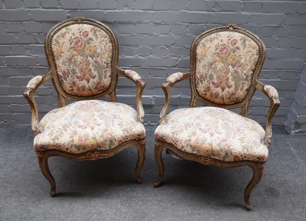 A pair of late 18th century French green painted open armchairs, with floral carved crest, serpentine seat and scroll supports, 61cm wide x 87cm high