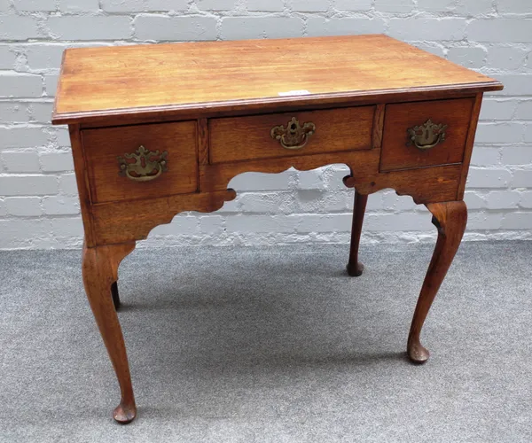 A mid-18th century oak lowboy with three frieze drawers on cabriole supports, 81cm wide x 71cm high x 50cm deep.