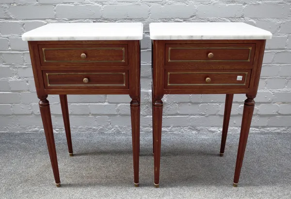 A pair of Louis XVI style bedside tables, each with marble tops over gilt metal mounted mahogany two drawer bases on tapering fluted supports, 41cm wi