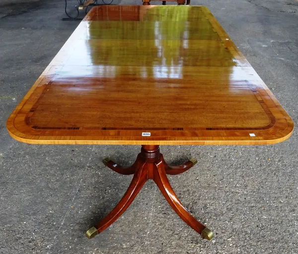 A rosewood banded mahogany twin pedestal extended dining table, incorporating George III timber, on eight downswept supports with two extra leaves, 11