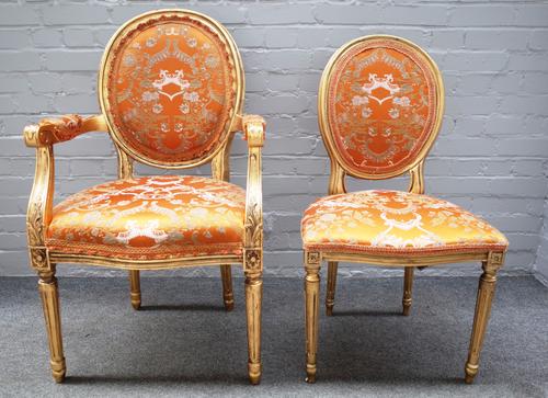 A set of eight gold painted open armchairs, of Louis XVI style, each with serpentine seat and fluted supports, 60cm wide x 102cm high, together with f