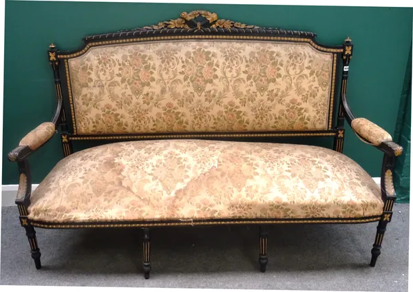 A 19th century parcel gilt ebonised open arm sofa, with flaming torch and quiver carved crest, above straight front seat, on turned and fluted support