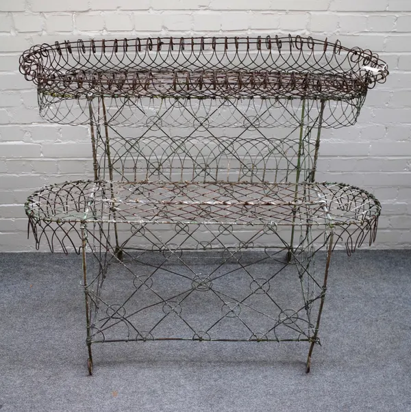 An Edwardian wire work double height oval plant stand, 133cm wide x 103cm high x 63cm deep.