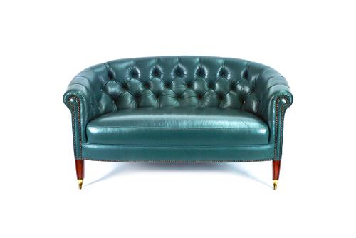 A small George III style green leather upholstered tub back sofa, on tapering square mahogany supports, 133cm wide x 69cm high.
