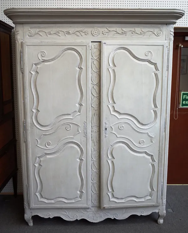 An 18th century and later white painted French armoire with a pair of shaped panel doors on scroll feet, 161cm wide x 210cm high x 68cm deep.