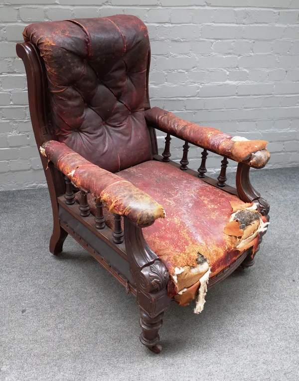 A Victorian mahogany framed rouge leather upholstered open armchair on turned supports, 70cm wide x 97cm high.