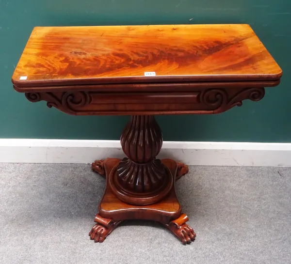 A Regency mahogany card table, the rounded rectangular top on a reeded baluster column and four paw feet, 81cm wide x 76cm high x 40cm deep.
