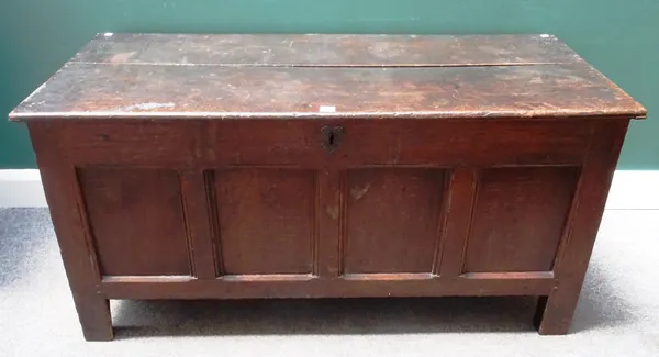 A 17th century oak coffer, the twin plank lid over a four panel front, on stile feet, 135cm wide x 65cm high x 59cm deep.