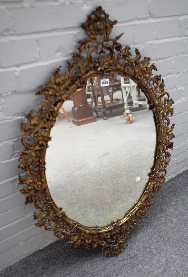 A 19th century floral cast ormolu oval mirror, with cartouche upper and lower frieze, 69cm wide x 107cm high.
