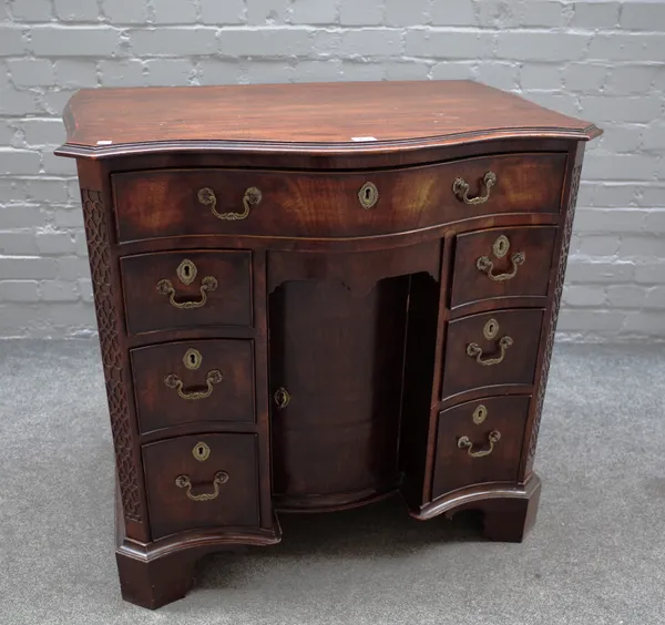 A Queen Anne style mahogany kneehole writing desk, 19th century, the serpentine top over seven drawers about the knee cupboard, 84cm wide x 82cm high