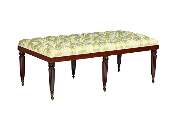 A large rectangular footstool, the button upholstered rectangular top on six reeded mahogany supports, 139cm wide x 51cm high x 70cm deep. Illustrated